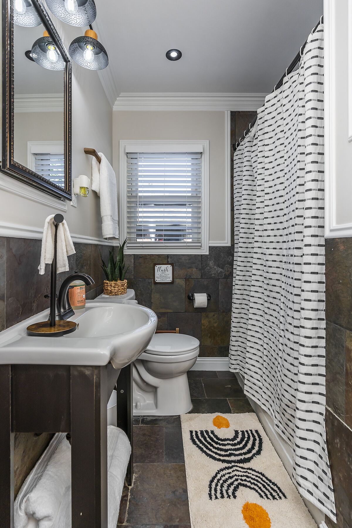 Une salle de bain moderne avec un lavabo blanc, des toilettes et un rideau de douche.