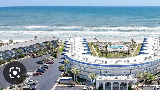 Un hôtel doté d’un bâtiment aux lignes courbes, d’une piscine et offrant une vue sur l’océan.