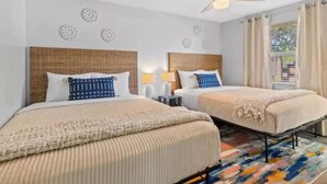 A hotel room with two beds, a ceiling fan, decorative wall art, and a view of the outdoors. - Newly renovated outdoor space, hot tub, fire pit,minutes from the beach. (Largo)