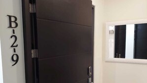 A dark wooden door with a handle, a white wall with the number "B-2-9" above it, and a small window with a white frame. - Cosy Loft - 3 Minutes From Airport SJO (Alajuela)