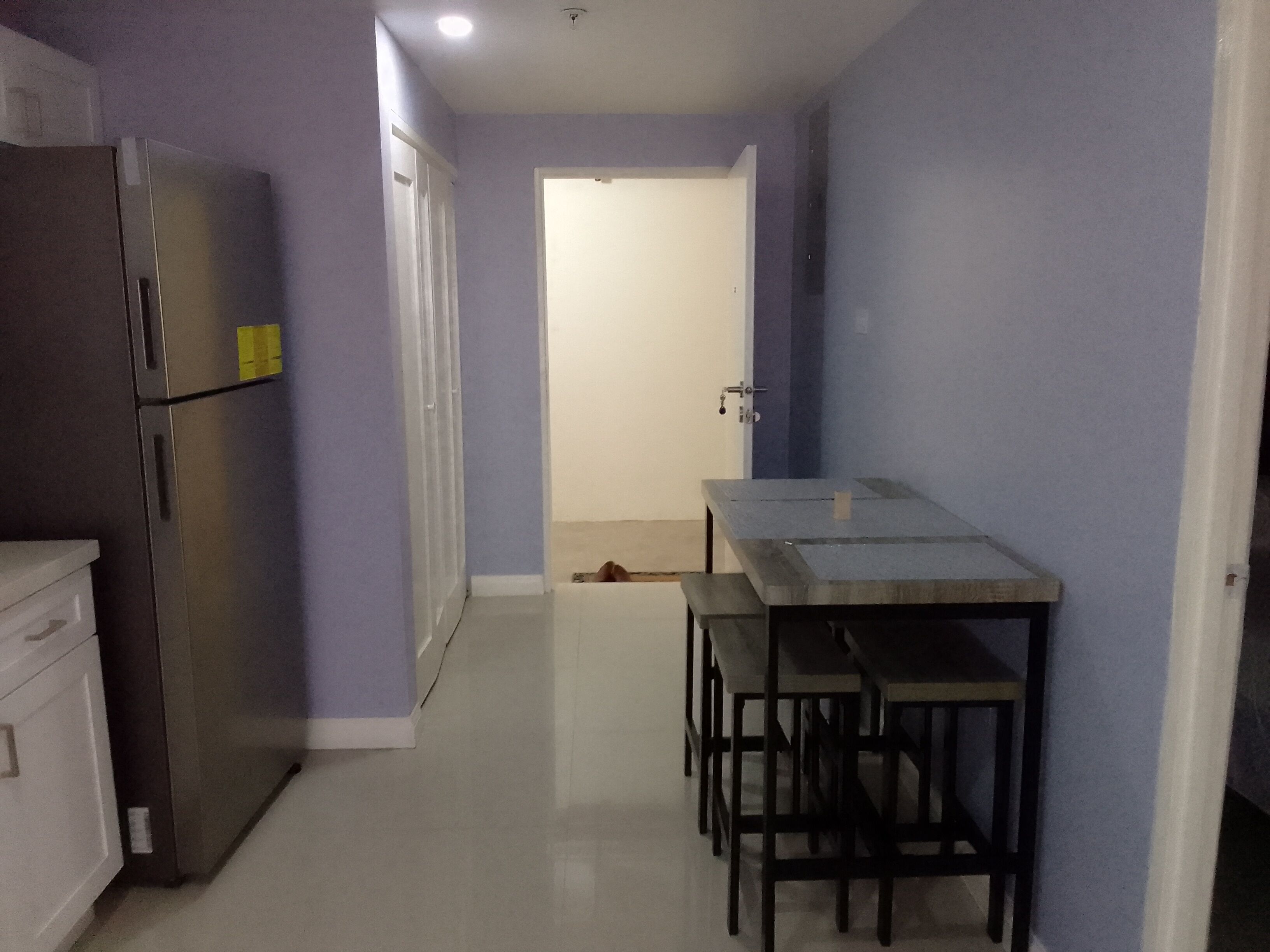 A compact kitchen with a refrigerator, a table, and two chairs.