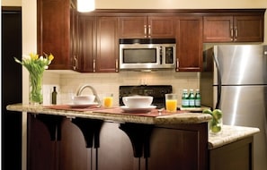 Enjoy cooking in this well-equipped kitchen with a sink, microwave, stove, and refrigerator.