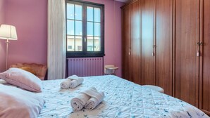 Une chambre à coucher avec un lit, une fenêtre, un radiateur et une armoire.
