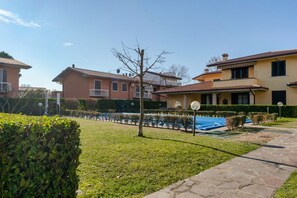 A residential area with houses, a lawn, and a pathway.