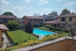 Un quartier résidentiel doté d’une piscine, entourée de pelouses et de haies bien entretenues.