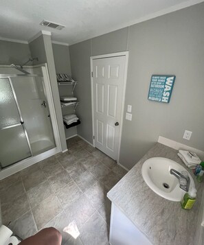 Bathroom features a walk-in shower, sink, and tiled floor.
