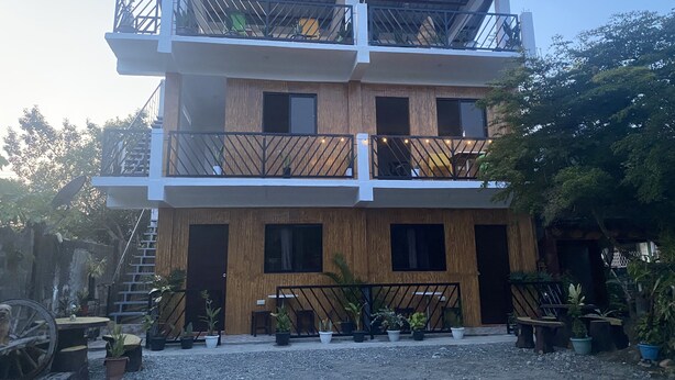 Un immeuble à plusieurs étages doté de balcons, de lambris en bois et de plantes en pot.