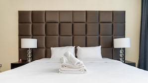 A neatly made bed with white linens, two bedside lamps, and a folded towel on the bed. - Modern, Charming, Sea View Apt. In Palm Jumeirah (Dubai)
