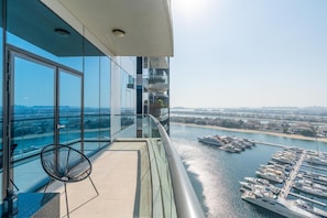 A modern building with a glass balcony overlooking a marina and a river.