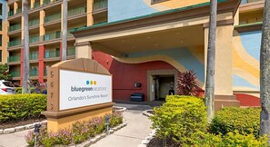 Experience the Sunshine Resort's welcoming entrance, surrounded by beautifully maintained gardens and a multi-story building with balconies.