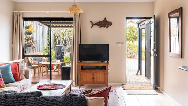 A living room with a TV, sofa, and dining area.