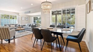 Un vaste espace de vie comprenant une table à manger, des chaises et un lustre.