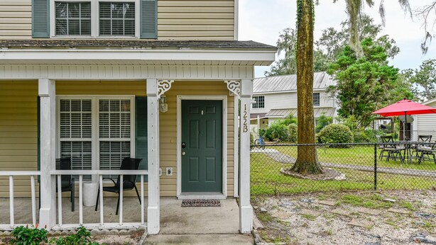 A two-story house with a front porch, a green door, and a mailbox. - Lovely home extremely close to Parris Island! (Port Royal)