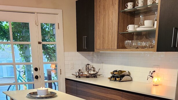 A modern kitchen with wooden cabinets, a white countertop, and a built-in wine rack.