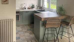 Een keuken met een groot kookeiland, een raam en een radiator.