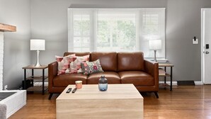 A living room with a brown leather sofa, a wooden coffee table, and two side tables with lamps. - Home with amazing location, 25min to Wintergreen, 30 min to Charlottesville, 20 min Staunton (Waynesboro)