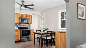 A kitchen with wooden cabinets, a microwave, an oven, and a dining table with chairs. - Home with amazing location, 25min to Wintergreen, 30 min to Charlottesville, 20 min Staunton (Waynesboro)