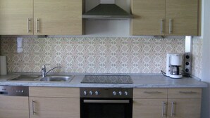 Una cucina con mobili in legno, un lavello in acciaio inossidabile, un fornello e una macchina da caffè.