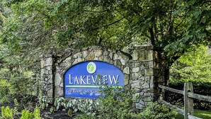 A sign for Lakeview Golf Resort & Spa, surrounded by lush greenery and a stone wall. - Lakeview Golf Resort Townhouses (Morgantown)