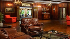 A cozy library with leather chairs, a fireplace, and bookshelves. - Lakeview Golf Resort Townhouses (Morgantown)