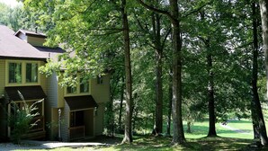 A two-story building with a stone foundation, multiple windows, and a porch area. - Lakeview Golf Resort Townhouses (Morgantown)