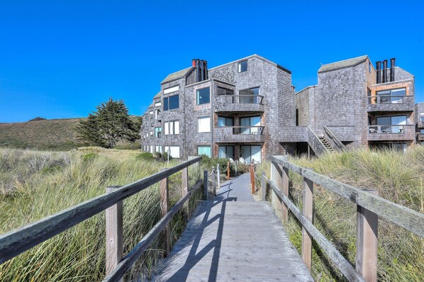 A modern building with a wooden walkway leading to the entrance.