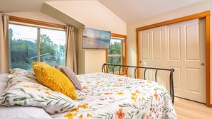 A bedroom with a bed, a window, a door, and a painting on the wall. - 3BR & 2.5BA centrally located home with AC, 2 Masters, 4 Smart TVs & Fiber Wifi! (Seattle)