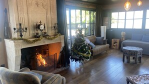 A cozy living room with a fireplace, a Christmas tree, and a sofa. - Maranatha Porto Vecchio (Porto-Vecchio)
