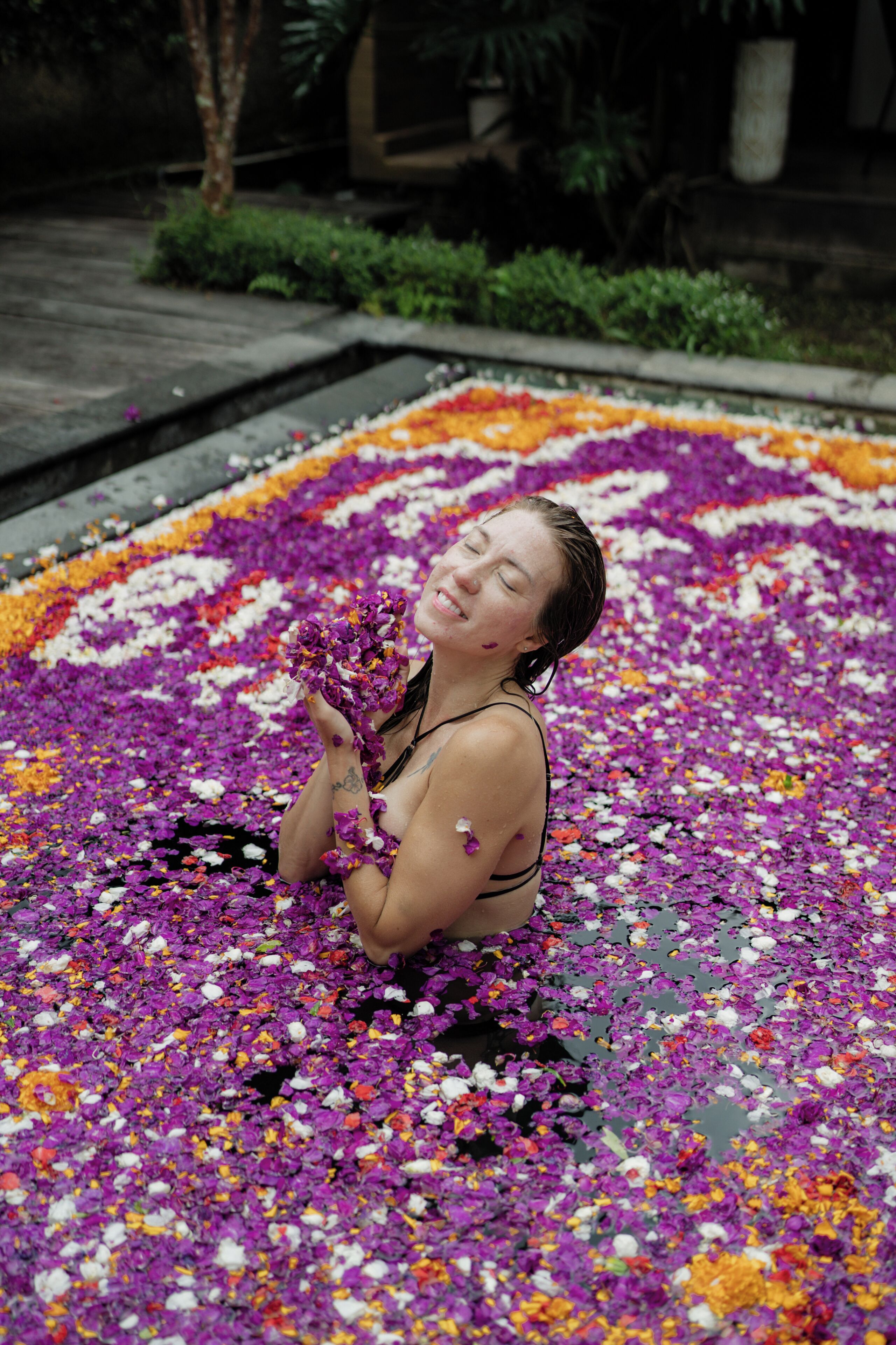 A person sitting in a flower-filled area.