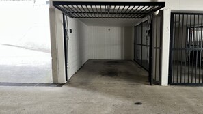 Un couloir propre et dégagé, avec une grille en métal et un mur recouvert de carreaux.