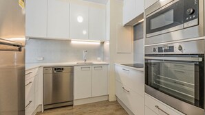 A modern kitchen with stainless steel appliances, white cabinetry, and a built-in dishwasher. - Seaspray U6 Ocean Views & Direct Beach Access (Kings Beach)