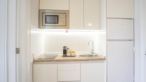 A compact kitchen with a microwave, sink, and a coffee maker on the countertop. - LA FAJANA ,vistas al mar con terraza y jardín priv (Los Realejos)