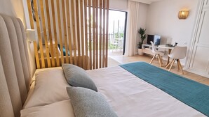 A hotel room with a bed, a desk with a TV, and a view of the outdoors. - LA FAJANA ,vistas al mar con terraza y jardín priv (Los Realejos)