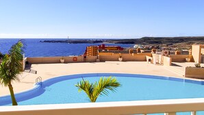 A rooftop pool with a view of the sea, surrounded by buildings and palm trees. - Coast, 4 people, sea and pool view, free WiFi  (Porís de Abona, Santa Cruz de Tenerife)