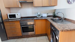 A compact kitchen with a microwave, toaster, coffee maker, sink, oven, and dishwasher. - Coast, 4 people, sea and pool view, free WiFi  (Porís de Abona, Santa Cruz de Tenerife)
