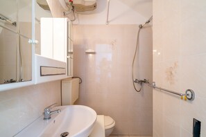 A bathroom with a sink, toilet, and shower.