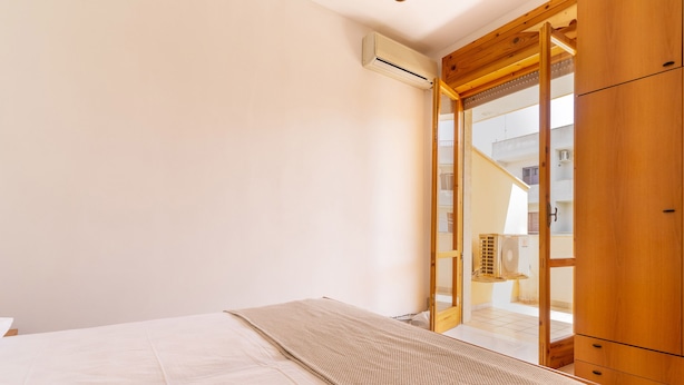 A bedroom with a bed, a wooden wardrobe, and a sliding glass door leading to a balcony. - 3055 Villetta Sunset by Barbarhouse (Gallipoli)