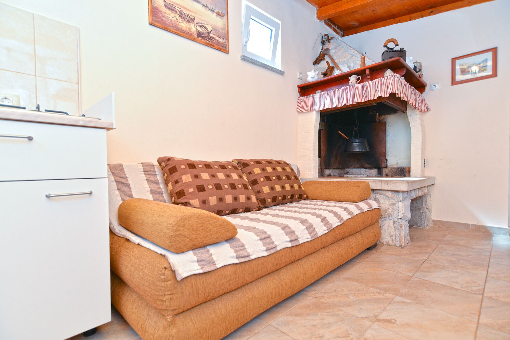 A cozy room with a sofa, a small table, and a fireplace.