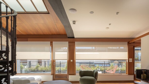 A spacious living area with a wooden ceiling, large windows, and a modern seating arrangement. - The Passage Apartments (San Sebastián)