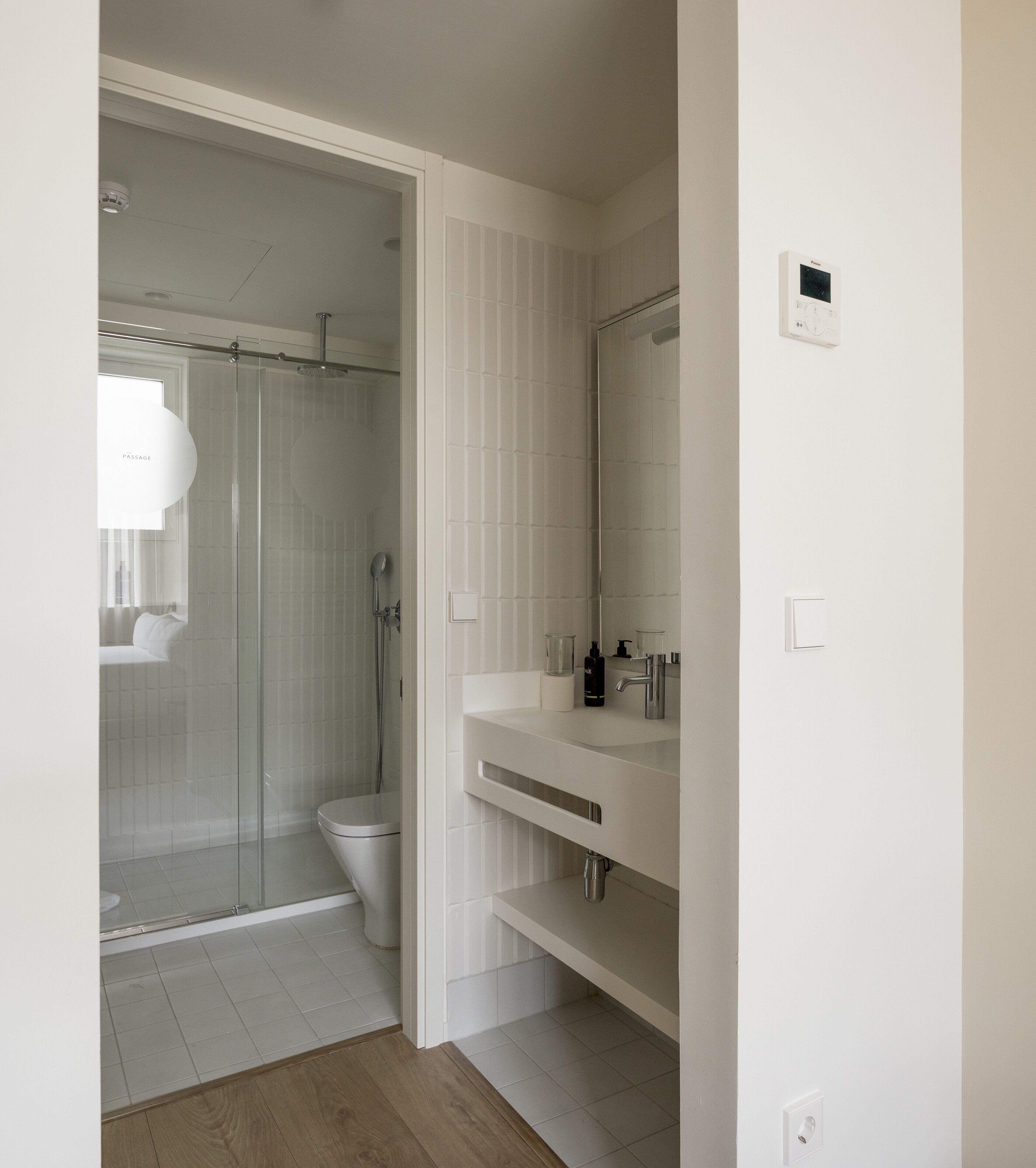 A modern bathroom with a glass-enclosed shower, a toilet, and a vanity with a mirror.