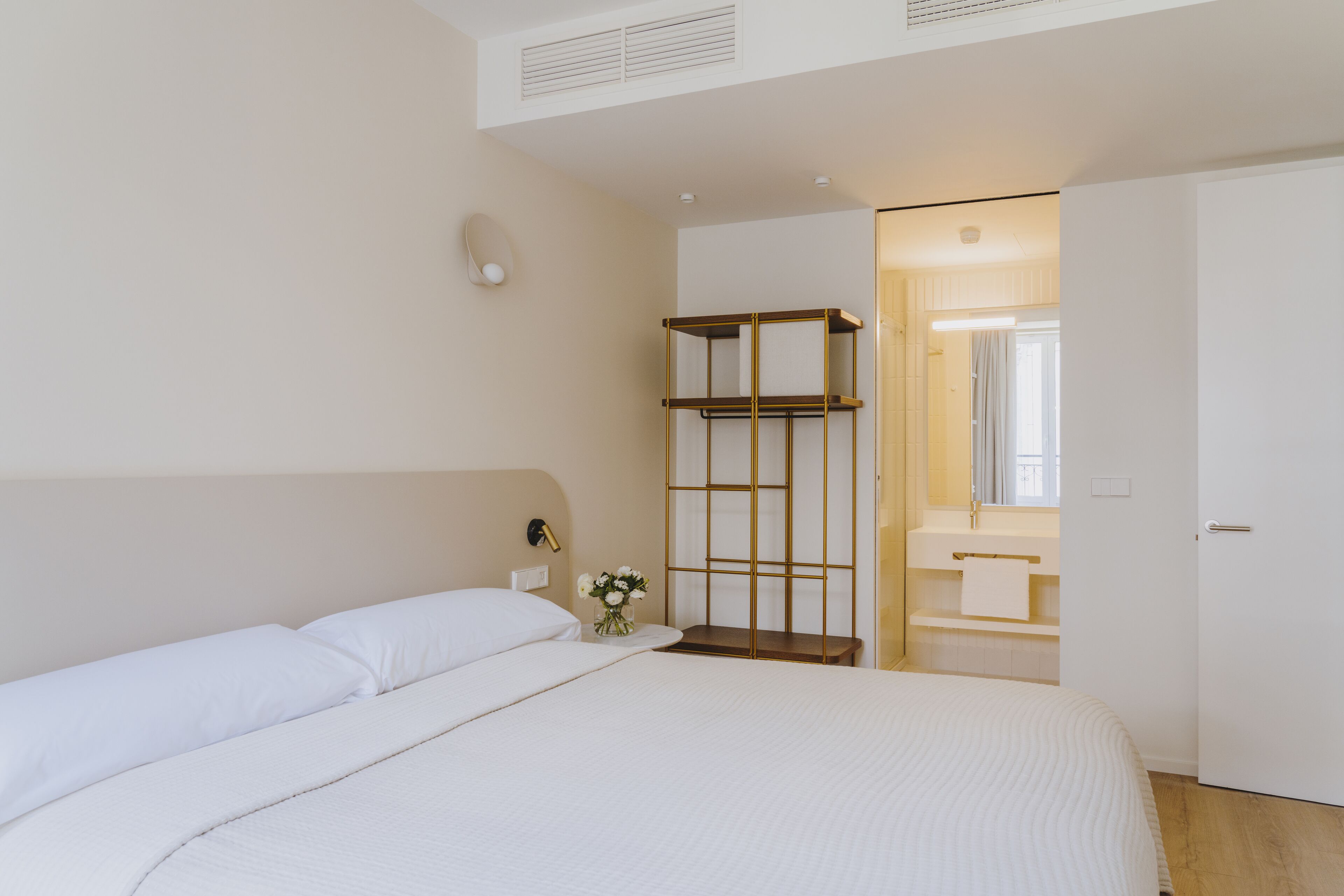Une chambre à coucher avec un lit, une table de chevet et un miroir.