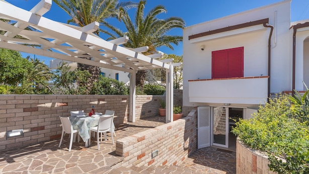 A patio with stone flooring, white chairs, and a table. - 2824 Villino Anna by Barbarhouse (Racale)