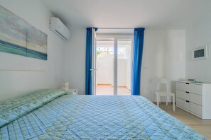 Quarto com cama, escrivaninha, cadeira e guarda-roupa.