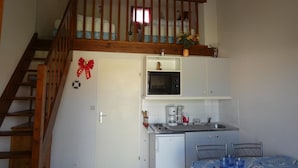 Cafetera o tetera, frigorífico, microondas y placa de cocina