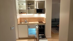 A compact kitchen with a built-in dishwasher, a stainless steel range hood, and a wooden countertop. - abba Apartments Playa de Gros San Sebastián (San Sebastián)