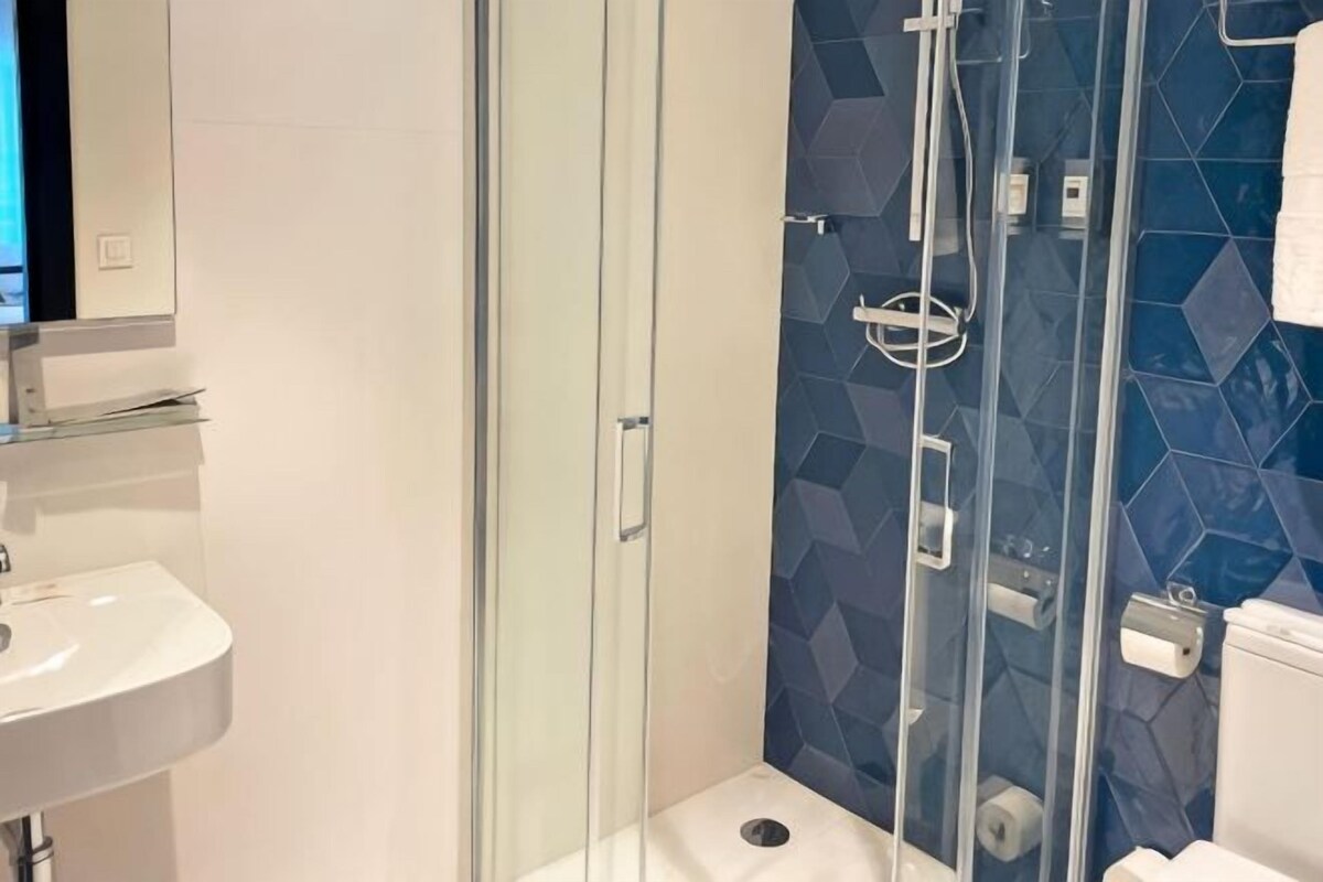 Ein Badezimmer mit Duschkabine, Waschbecken in Weiß und Toilette.
