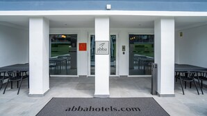 The entrance of Abba Hotels with a modern design, featuring a glass door entrance, a signboard, and a website address on the floor mat. - abba Apartments Playa de Gros San Sebastián (San Sebastián)