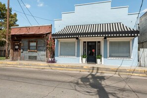 A two-story building with a blue facade and a black and white striped awning. - Side-By-Side Both Places, Groups Can Spend More Time Together! (New Iberia)