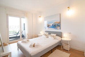 Un dormitorio con una cama grande, vistas al exterior y un cuadro en la pared.
