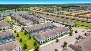 Zona residencial con varios edificios de apartamentos, piscina y un lago.